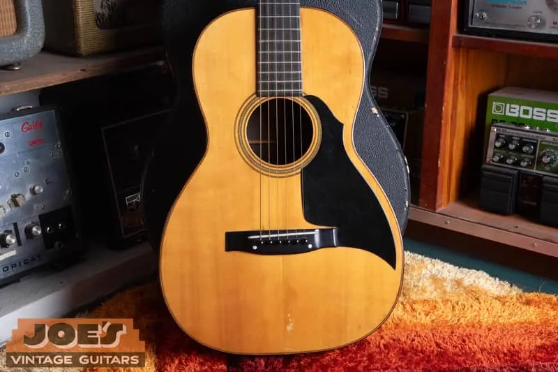 Front of a refinished 1923 Martin 0-21 with a pointed black pickguard and replacement bridge.