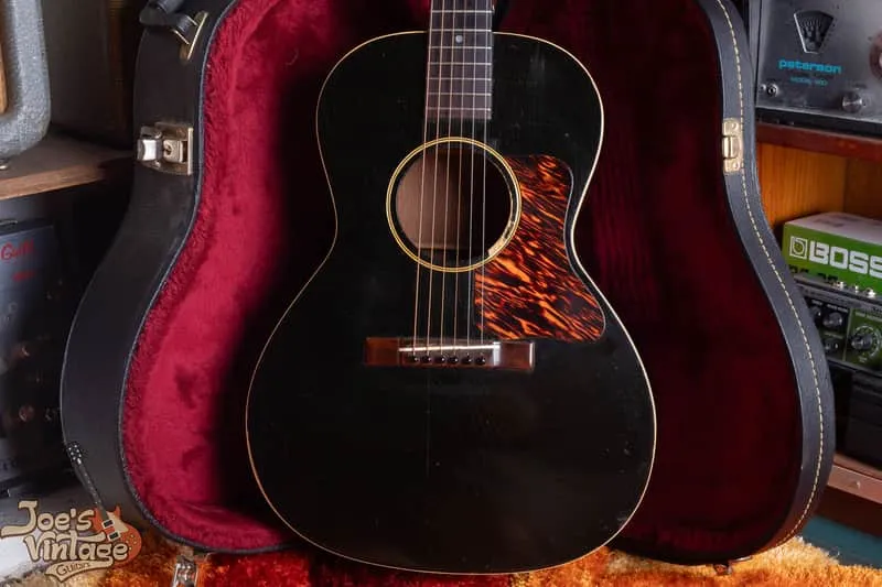 Black Gibson L-0 with firestripe pickguard, dot markers and rectangular bridge in a red-lined case