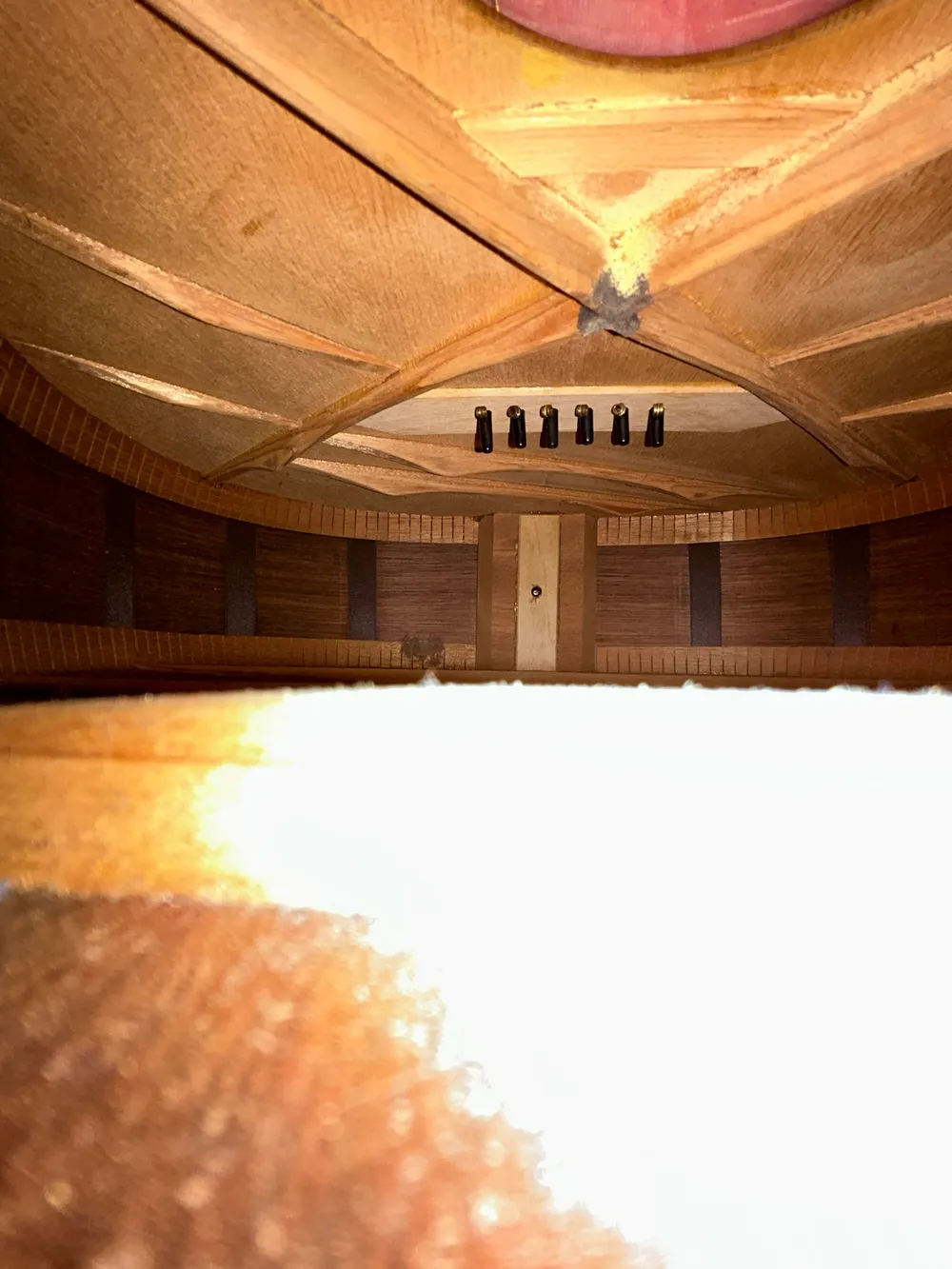 Interior of a 1936 Martin 00-21 showing the soundhole edge, X-brace crossing and bridge plate