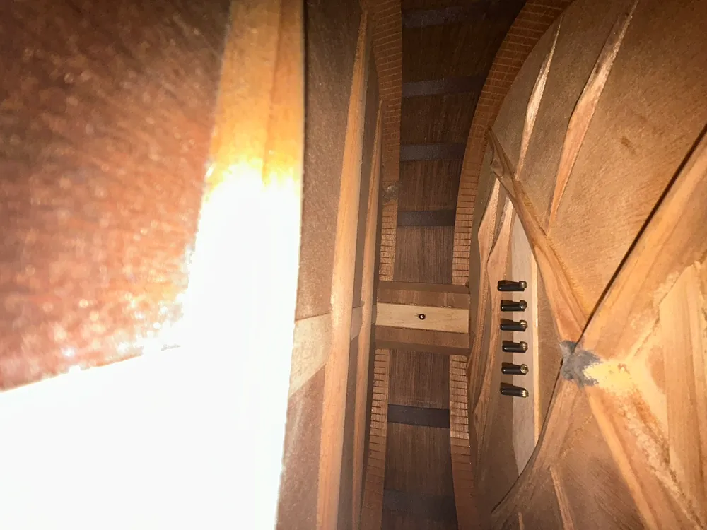 Side-angle interior view of the bridge plate, pins and X-braces in a 1936 Martin 00-21
