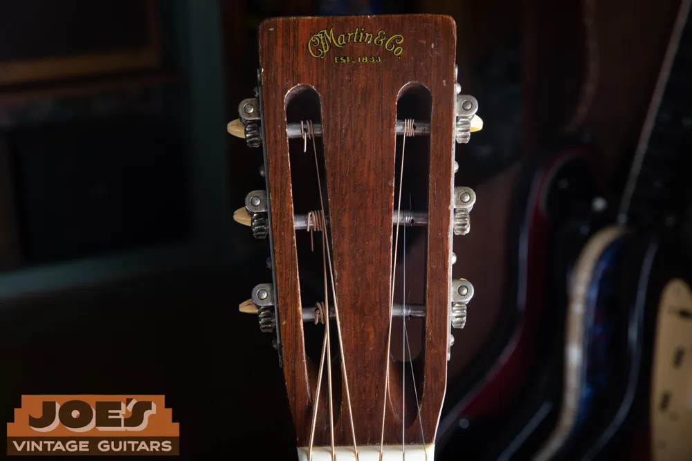 Slotted headstock of a 1947 Martin 00-21 with string posts across the slots and side-mounted strip tuners