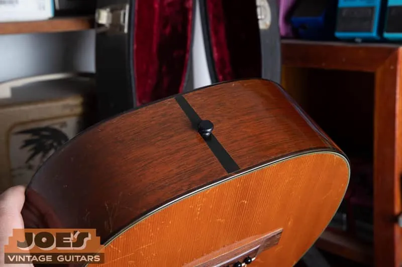 Side and lower bout of a 1950 Martin 5-18, mahogany side grain and end wedge, with the open case behind it.