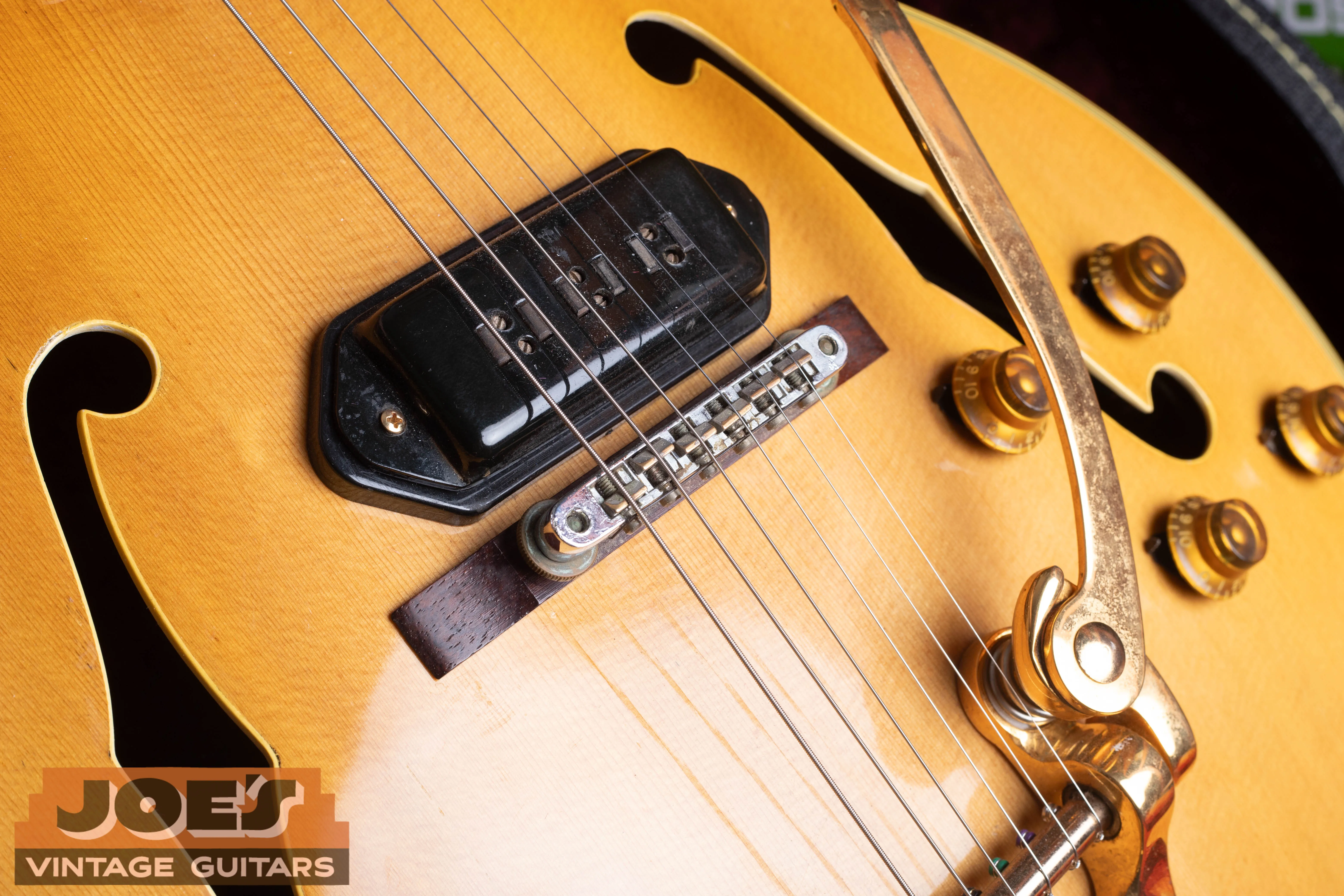 Black Alnico pickup with rectangular pole pieces, bridge, knobs and tailpiece on a natural-finish L-5 CES.