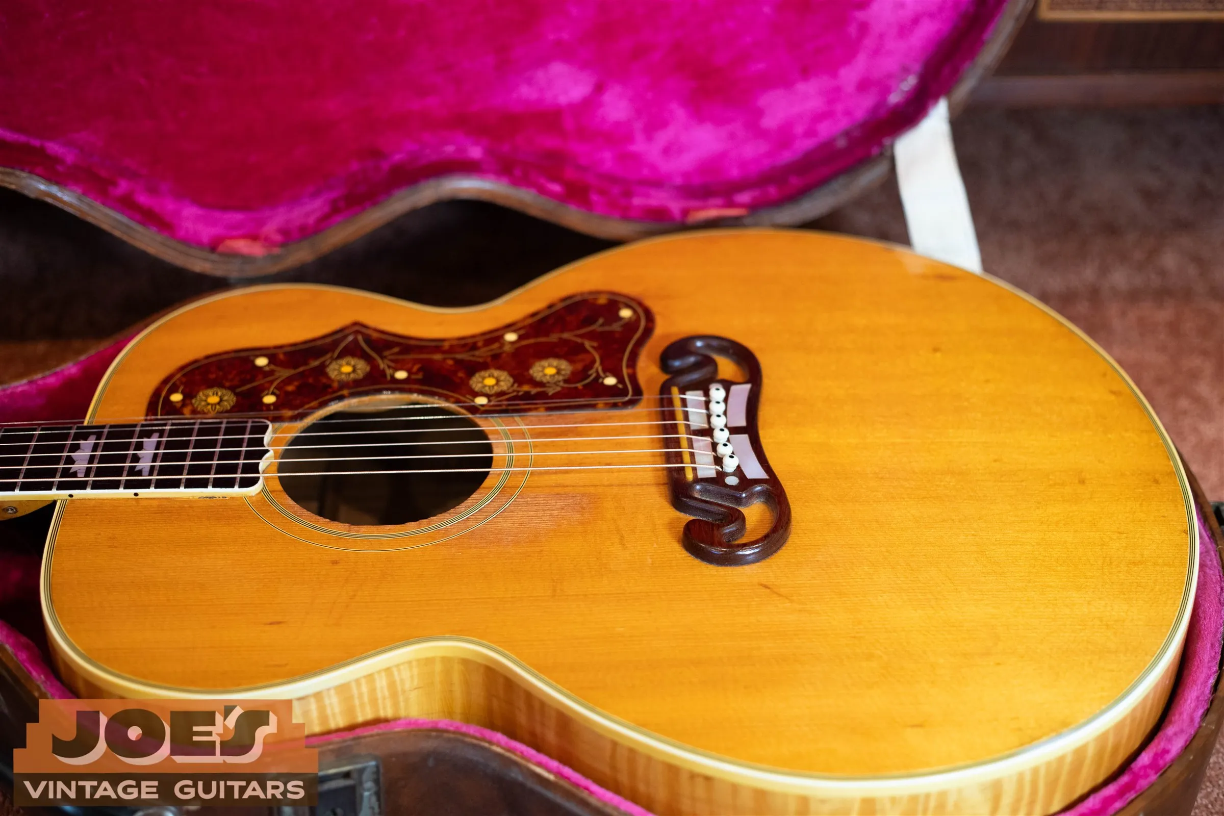 Close view of a J-200 open moustache bridge, light bridge pins and floral pickguard