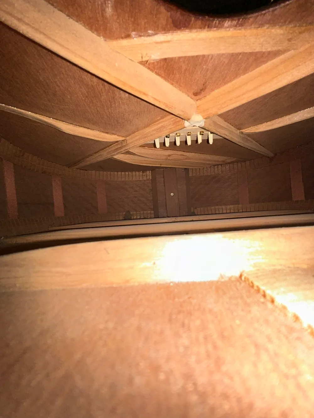 Postwar X-braces and light-colored bridge pins inside a 1954 Martin 00-17