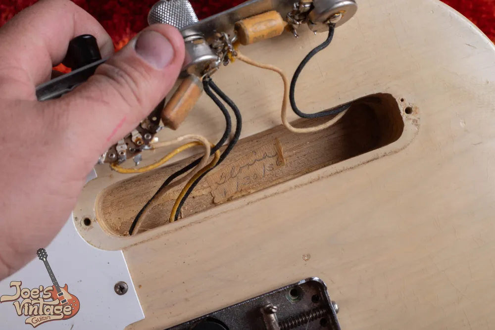 Masking-tape strip carrying a worker notation and 1956 date inside a blonde Fender Telecaster