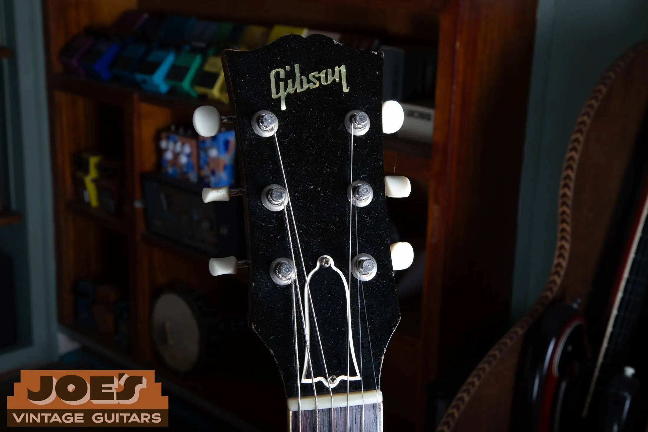 Front of a 1956 Gibson ES-225 headstock with pearl logo and truss rod cover