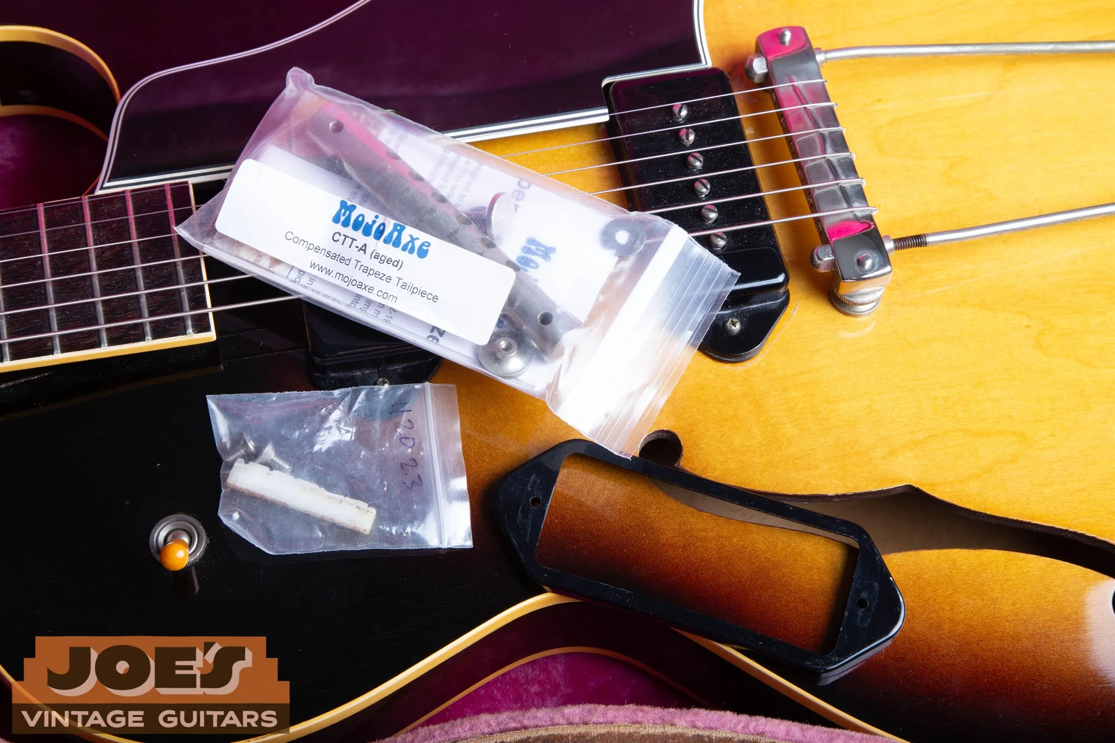 Gibson ES-225 hardware and pickguard removed during inspection with a replacement tailpiece package