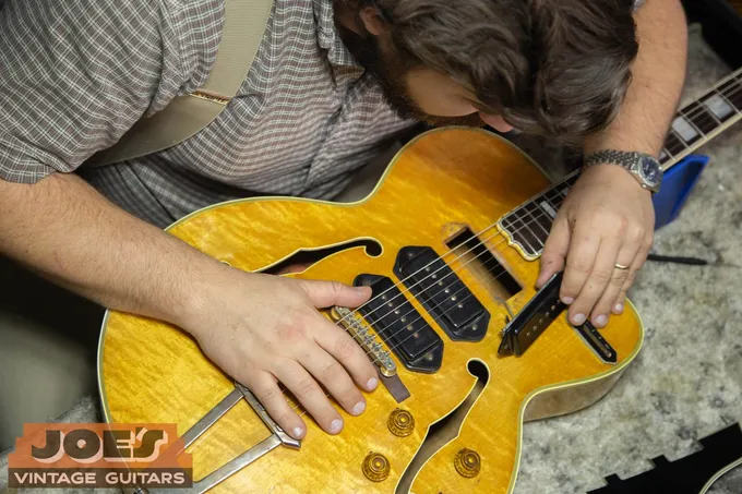Joe&rsquo;s Vintage Guitars specialist closely examining the top and binding of a 1956 Gibson ES-5 during an in-person appraisal