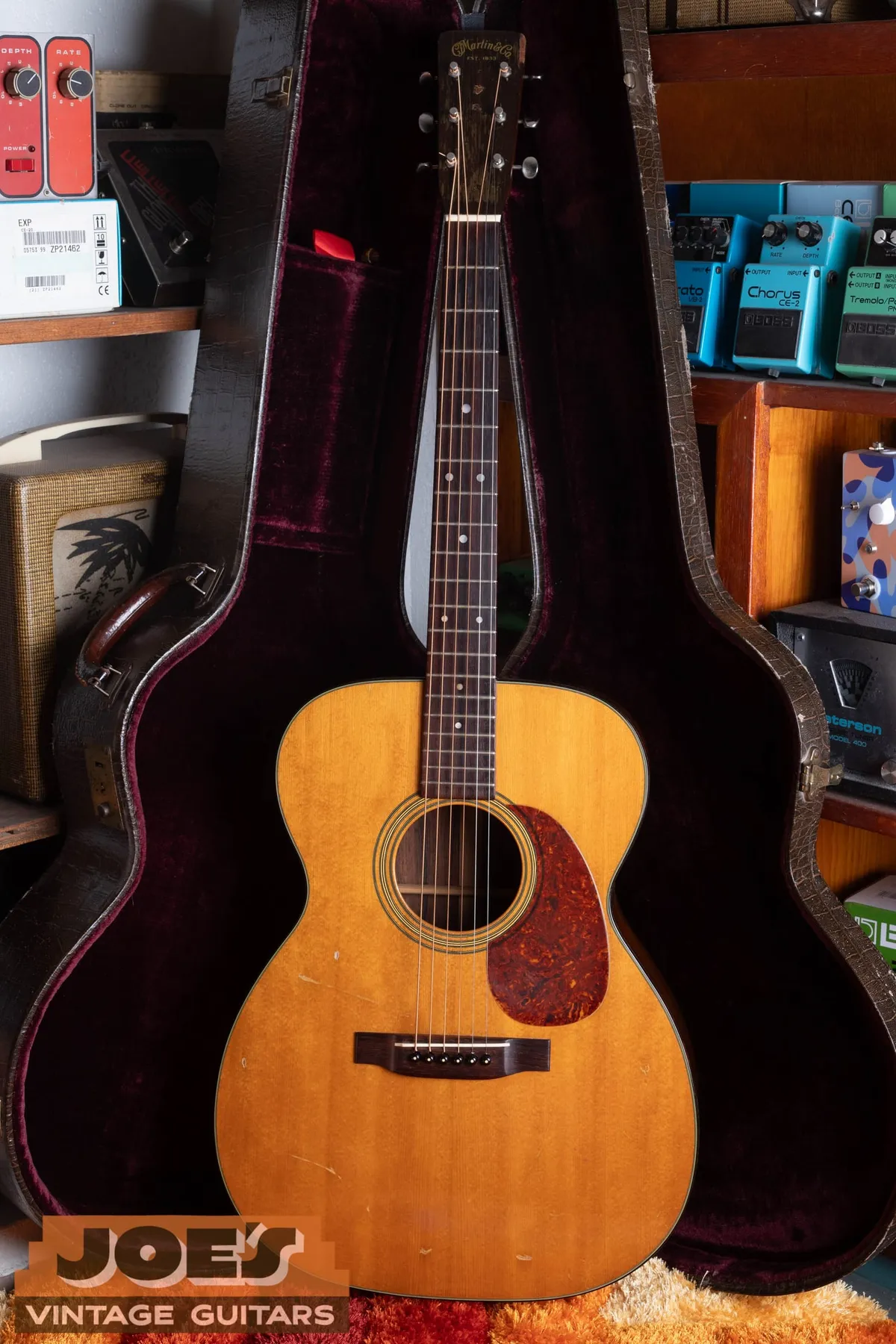 Full front view of the 1956 Martin 000-21 in its burgundy-lined hardshell case