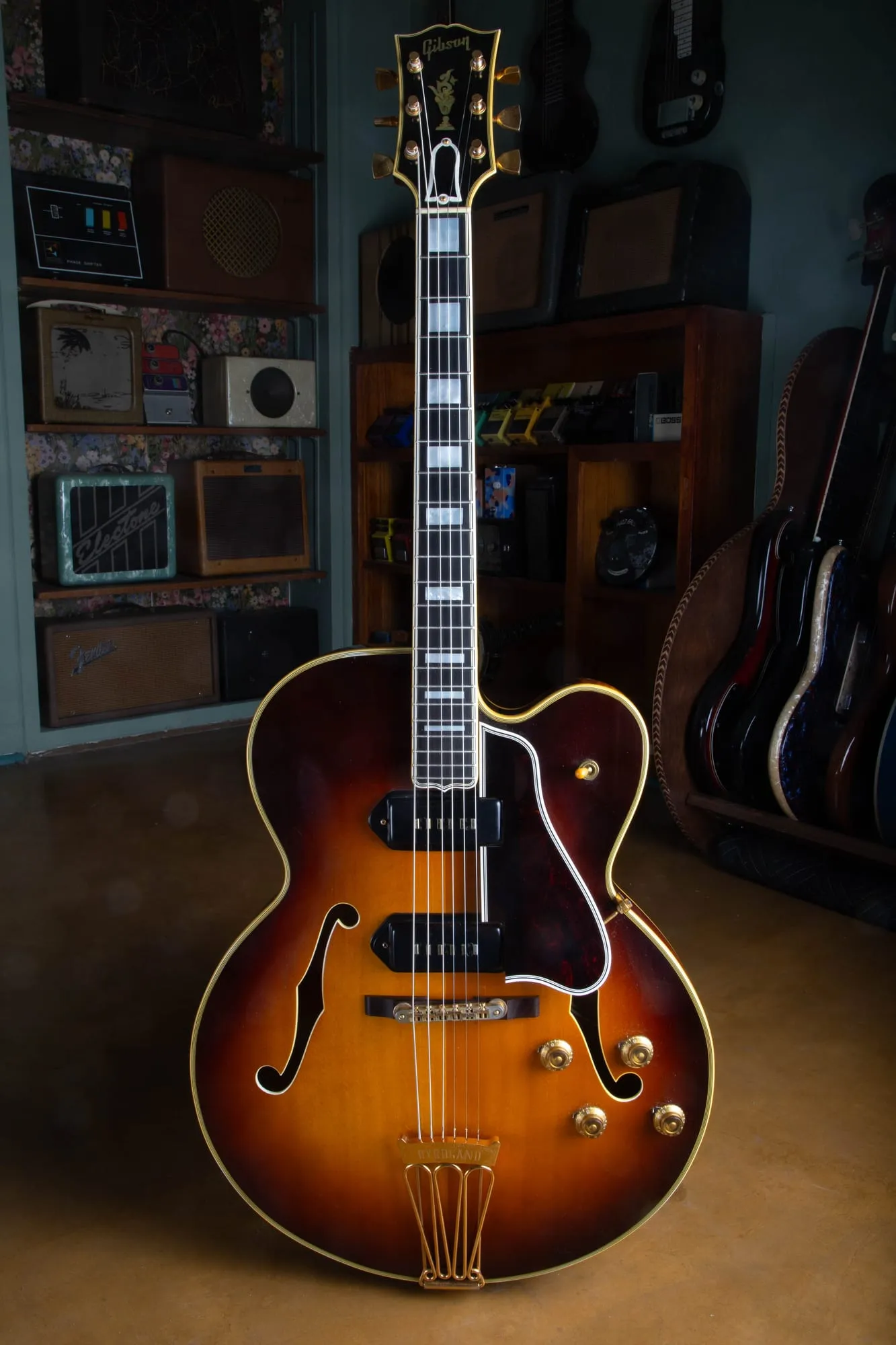 Full front of a 1957 Gibson Byrdland thinline archtop in sunburst with gold hardware, standing upright