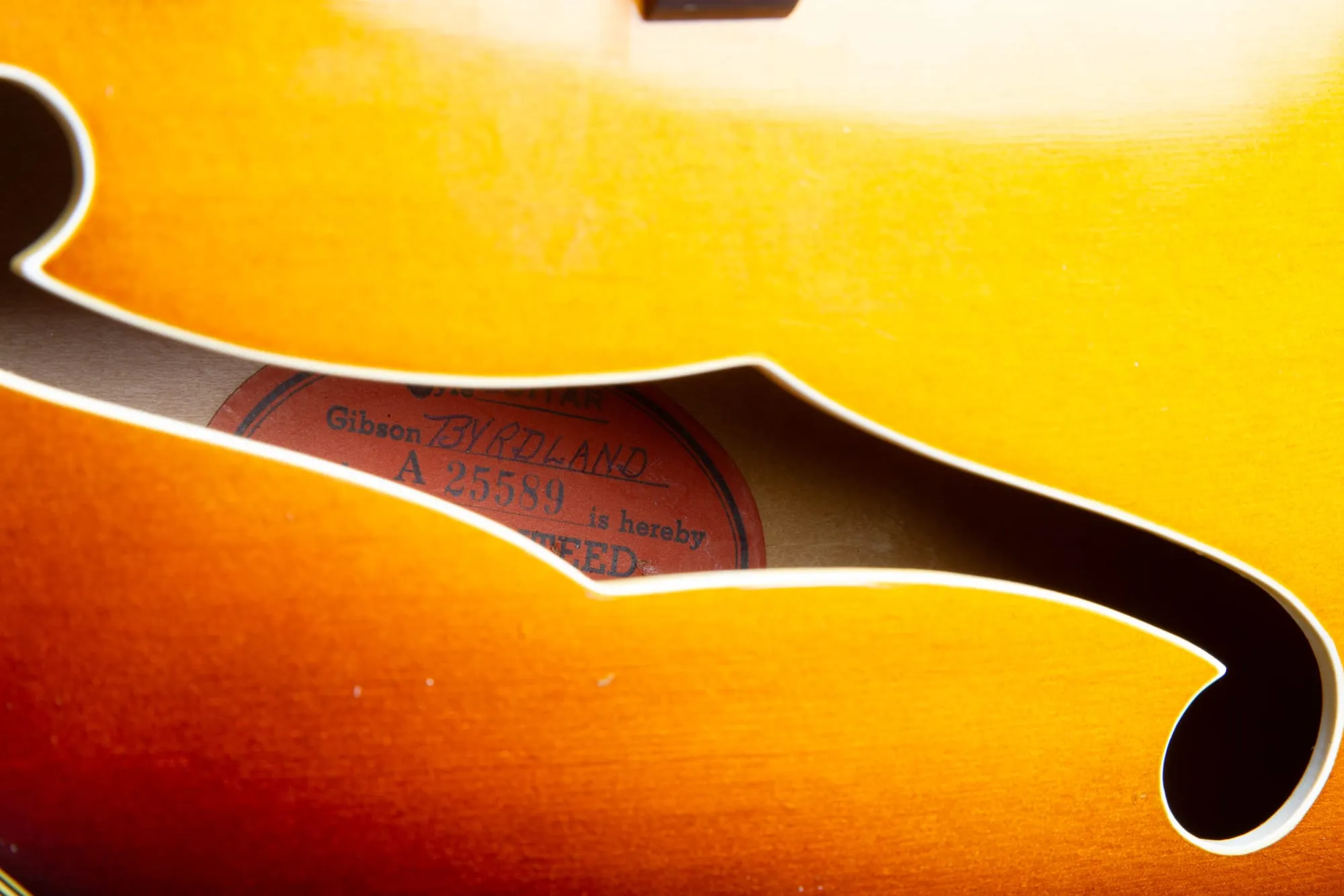 Orange oval Gibson label inside the f-hole of a 1957 Byrdland reading Byrdland, serial number A 25589