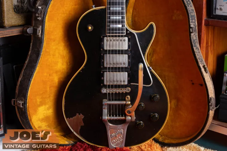 Straight-on body view of a 1958 Gibson Les Paul Custom with three pickups and a Bigsby vibrato