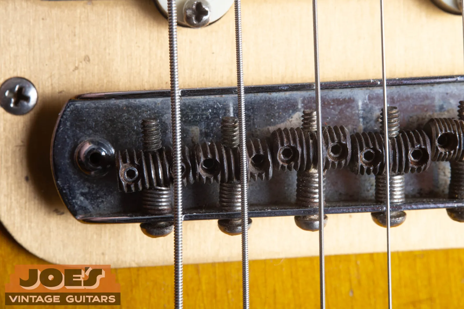 The floating bridge of a 1959 Fender Jazzmaster with six individual threaded barrel saddles in a rocking chrome base