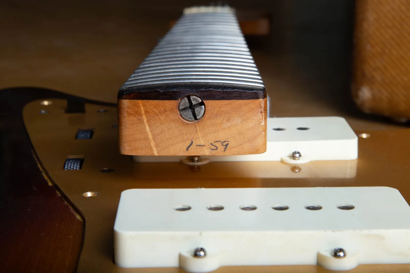 The neck heel of a 1959 Fender Jazzmaster penciled 1-59, with the body-end truss rod nut visible