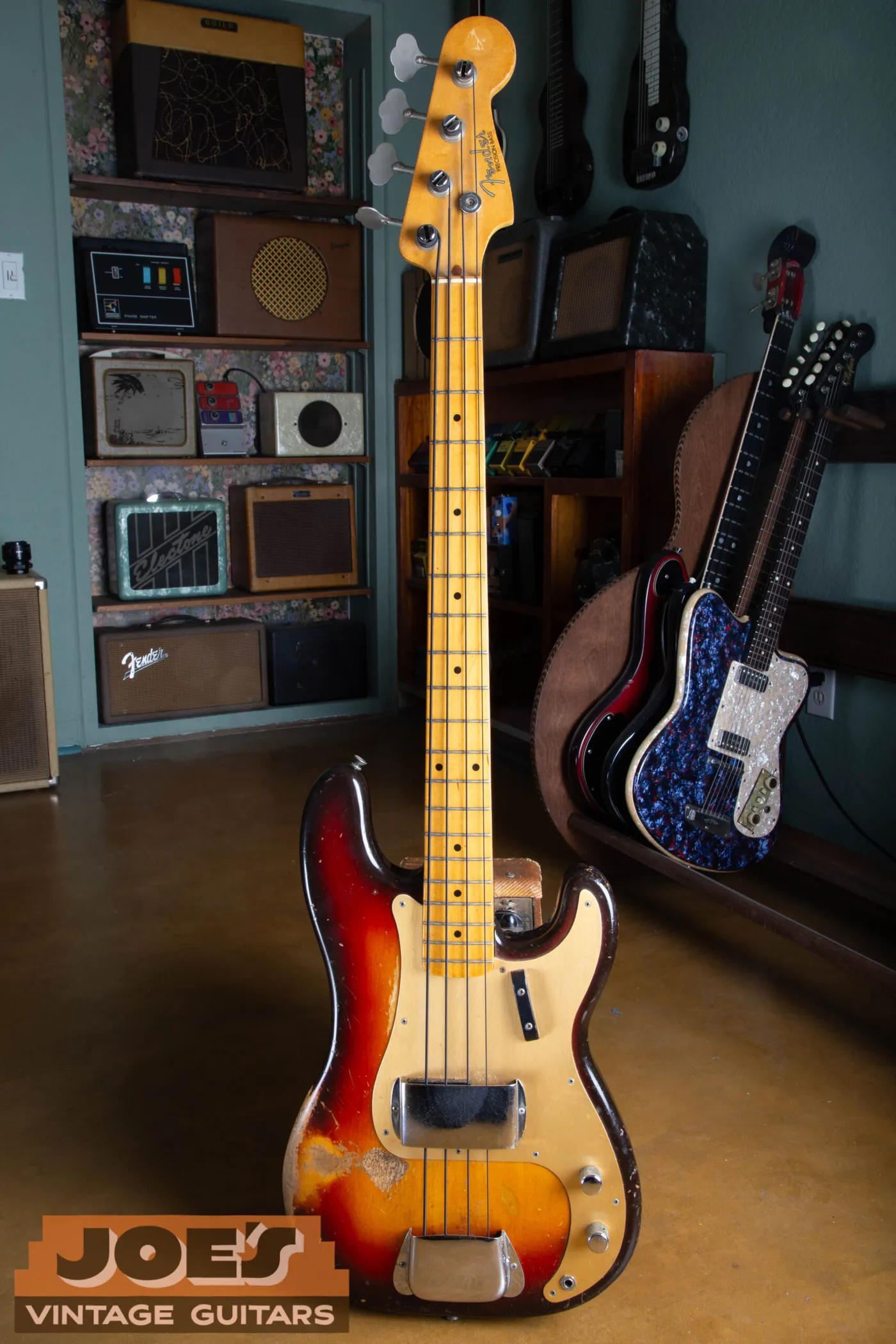 Full body shot of a 1959 Fender Precision Bass with a gold anodized aluminum pickguard and a maple fingerboard
