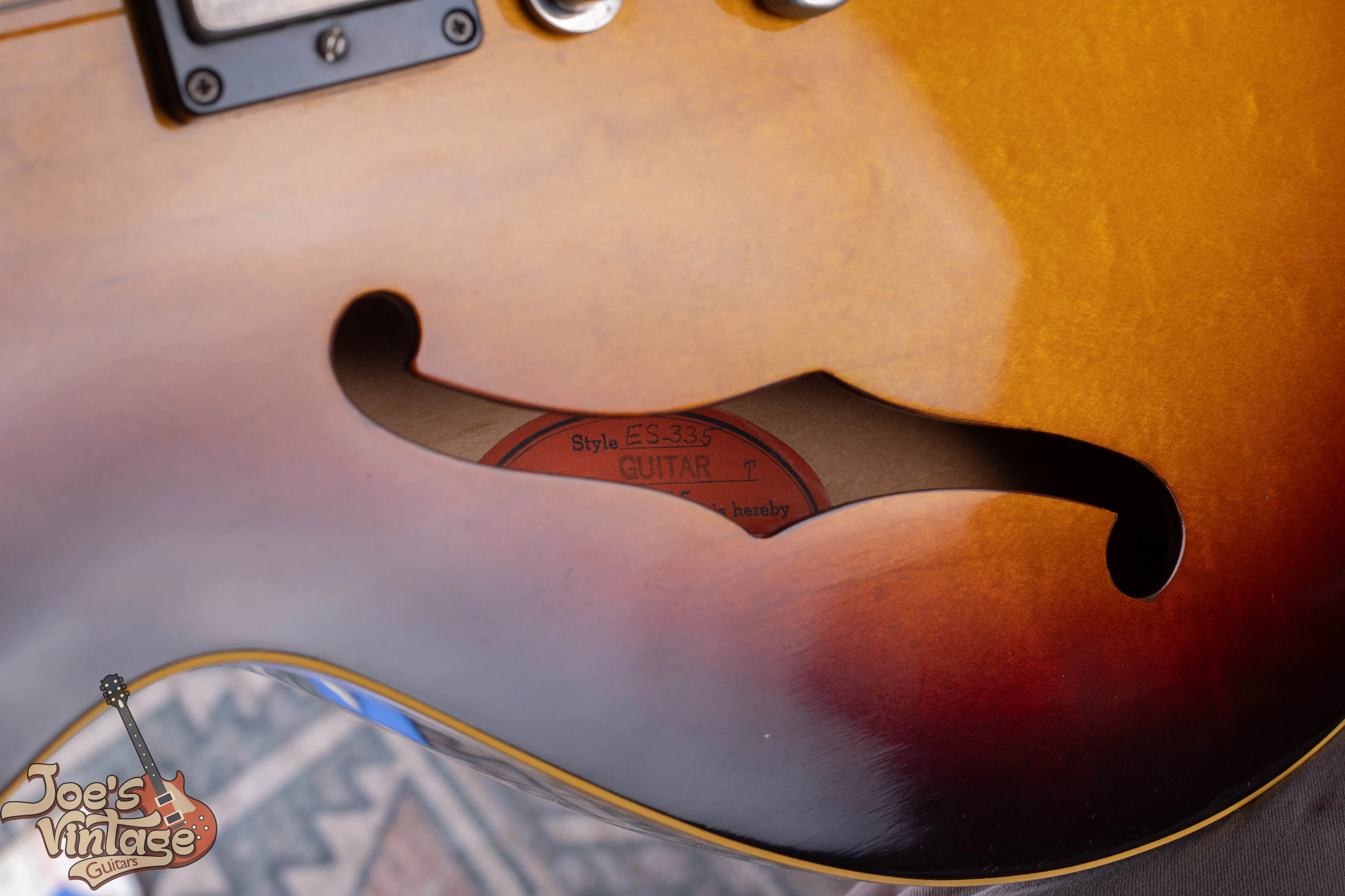 Close-up of an original Gibson orange oval label inside the f-hole of a 1959 ES-335 showing the model name.