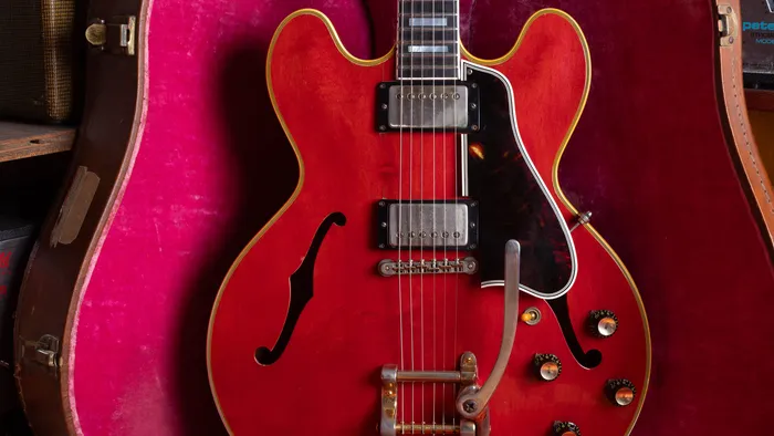 1959 Gibson ES-355 in cherry with a gold Bigsby, resting in a pink-lined brown case on the bench at Joe's Vintage Guitars in Mesa.
