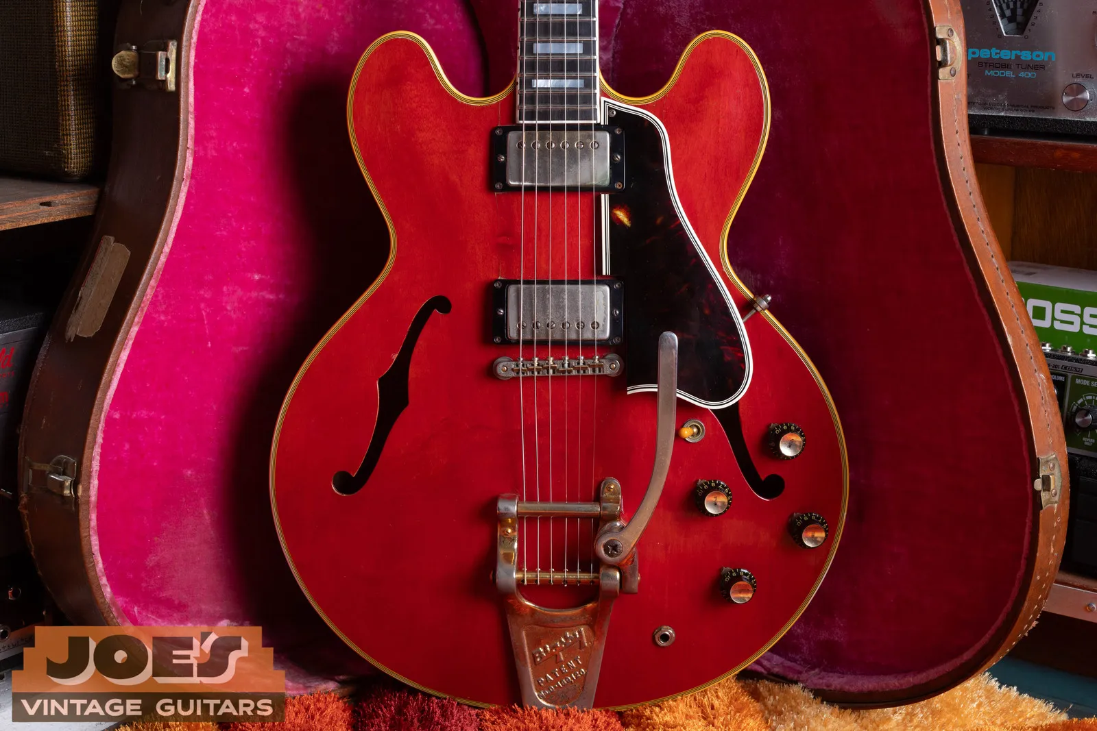 1959 Gibson ES-355 in cherry with gold Bigsby, standing in a pink-lined brown case in the Mesa shop.