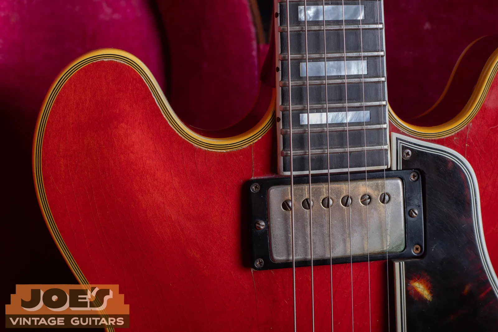 Neck pickup, ebony board, and pearl block inlays on a 1959 Gibson ES-355 in cherry, in a pink-lined case.