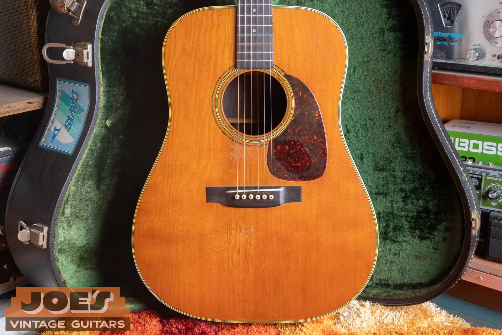 1959 Martin D-28 in a green-lined hardshell case, spruce top with a tortoise pickguard.