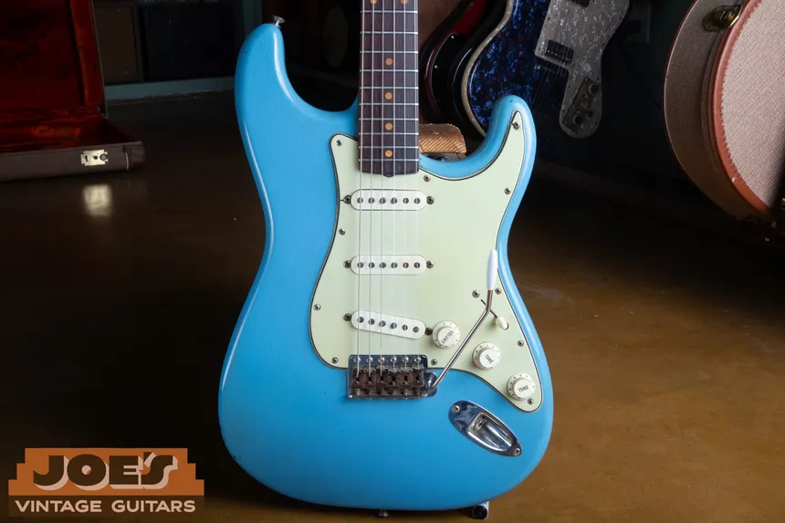 Front of a refinished 1960 Fender Stratocaster in light blue with a mint pickguard.