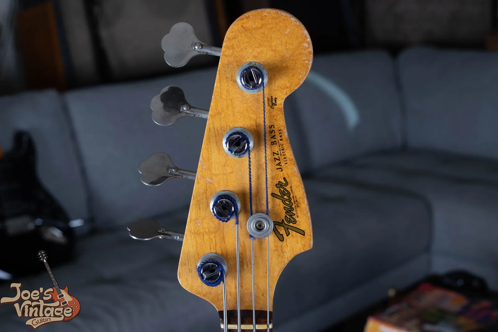 The headstock of a 1961 Fender Jazz Bass with the gold Fender Jazz Bass logo and clover leaf Kluson tuners