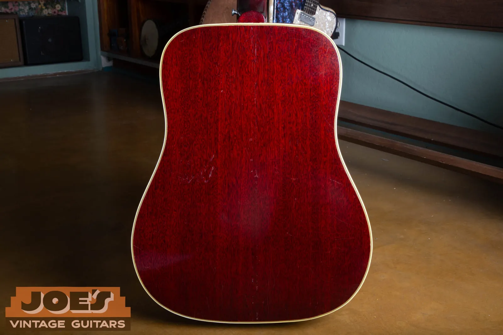 Back of a 1961 Gibson Hummingbird showing the two piece Honduras mahogany back finished in cherry with cream binding.