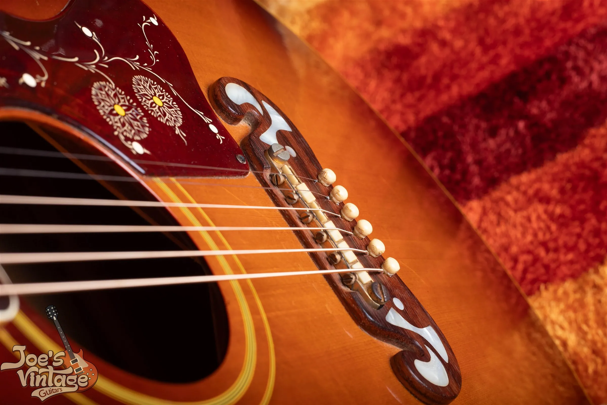 Gold adjustable saddles and light string pins on a J-200 moustache bridge