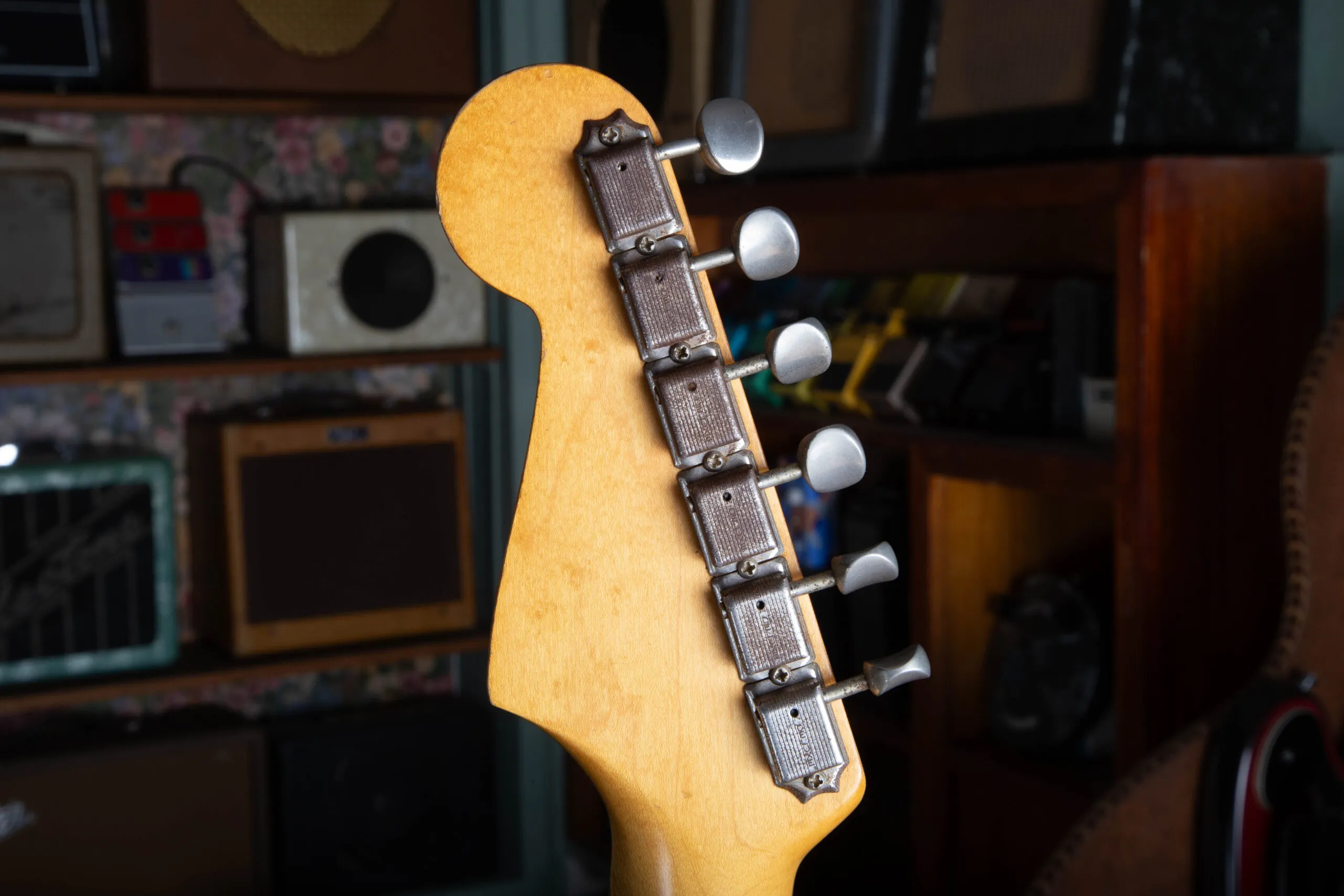 Back of the headstock on a 1963 Fender Stratocaster showing Kluson Deluxe single-line tuners with oval metal buttons