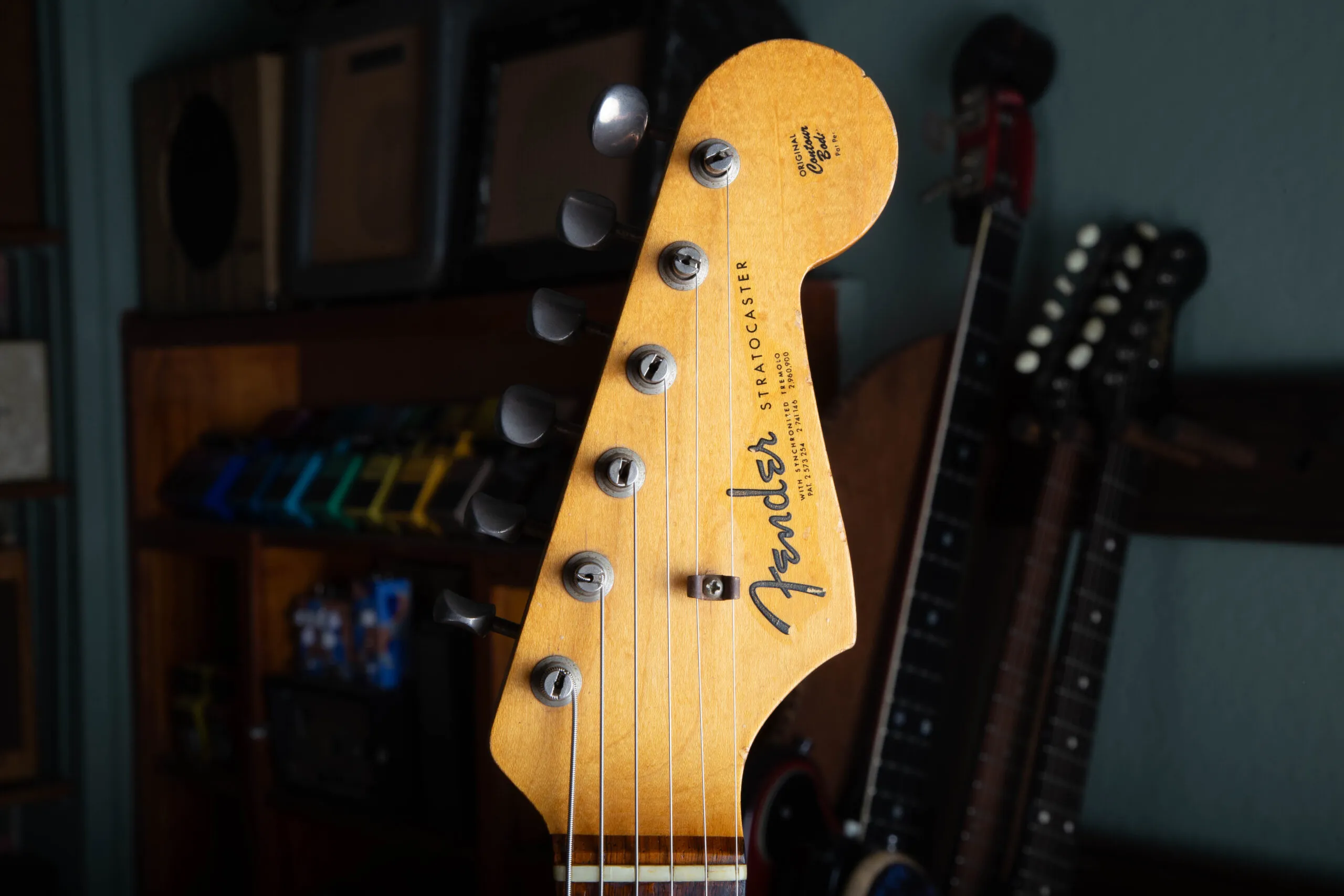 Front of the headstock on a 1963 Fender Stratocaster showing the gold spaghetti logo and three patent numbers