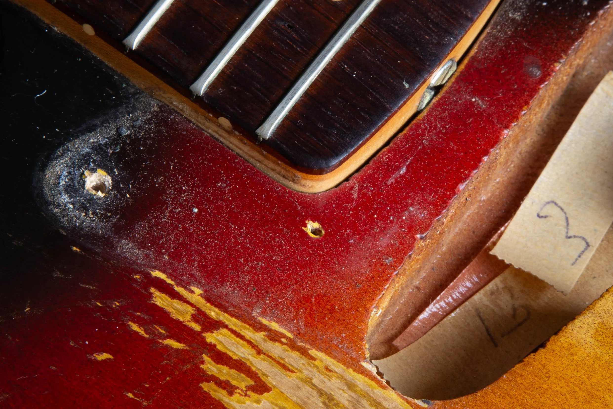 Nail hole near the neck pickup cavity of a 1963 Fender Stratocaster, bare wood inside, leftover from the painting process