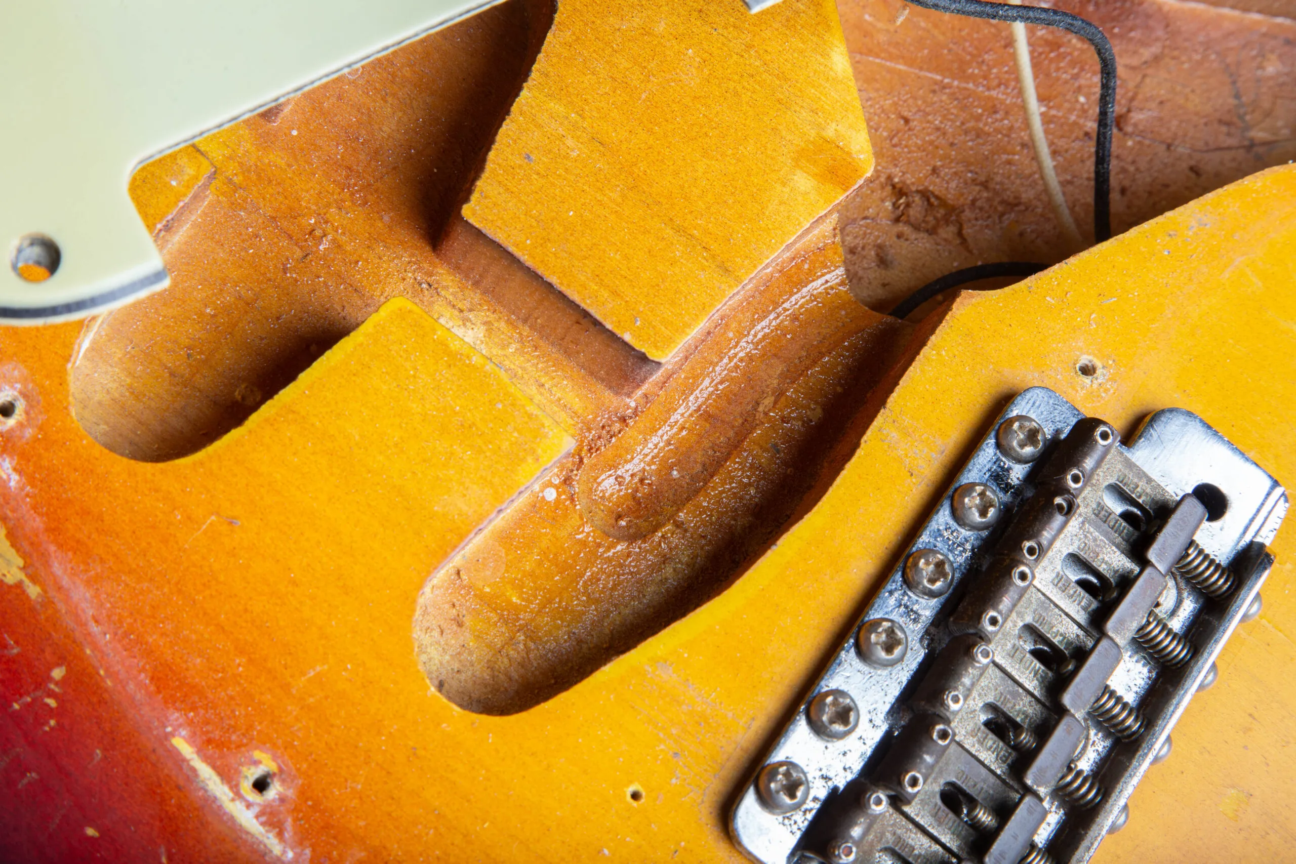Rough router channel in the bridge pickup cavity of a 1963 Fender Stratocaster with original wood flakes still on the edges