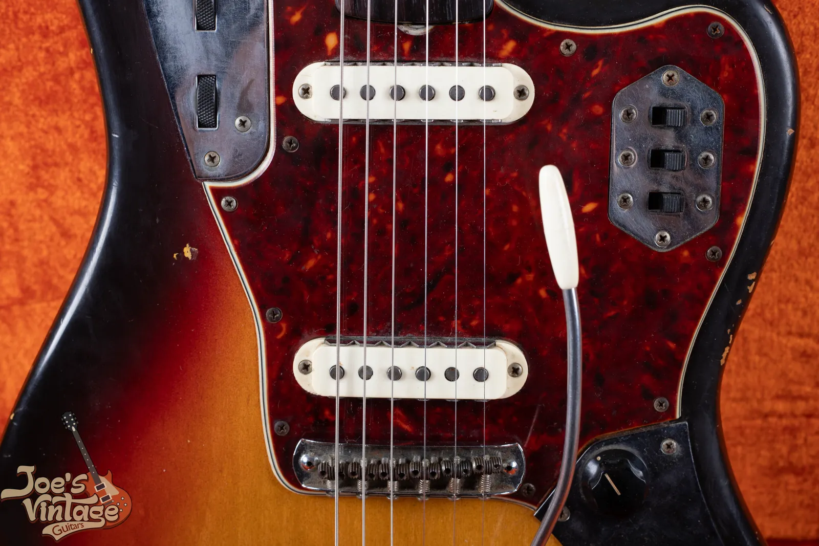 A pair of single coil pickups on a 1964 Fender Jaguar showing the notched metal claw shielding plates wrapping around three sides of each pickup