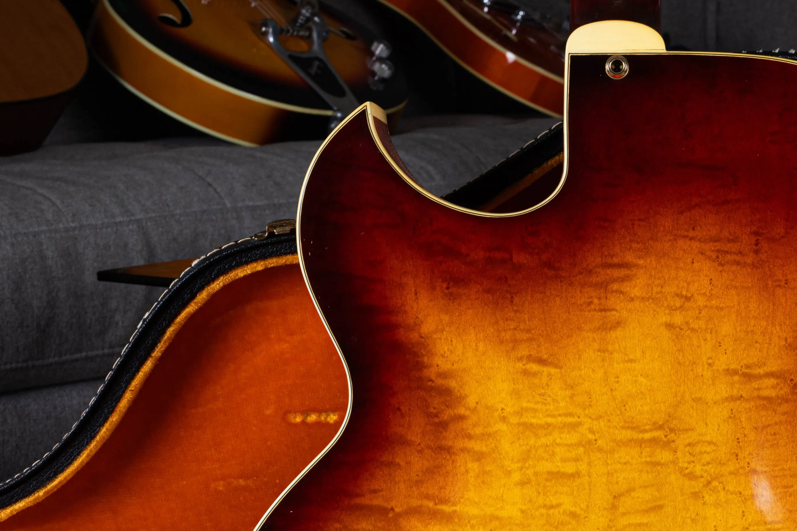 Rear view of a pointed L-5 cutaway with sunburst figured wood, binding and a strap button.