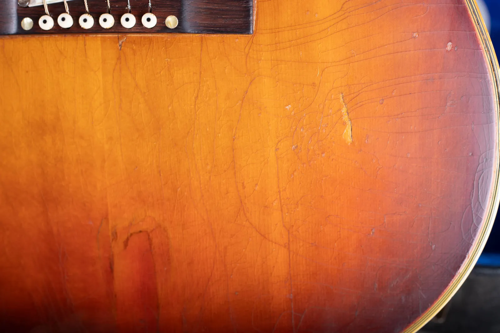 Top of a well played 1964 Gibson Hummingbird showing heavy nitrocellulose finish checking across the faded sunburst spruce.
