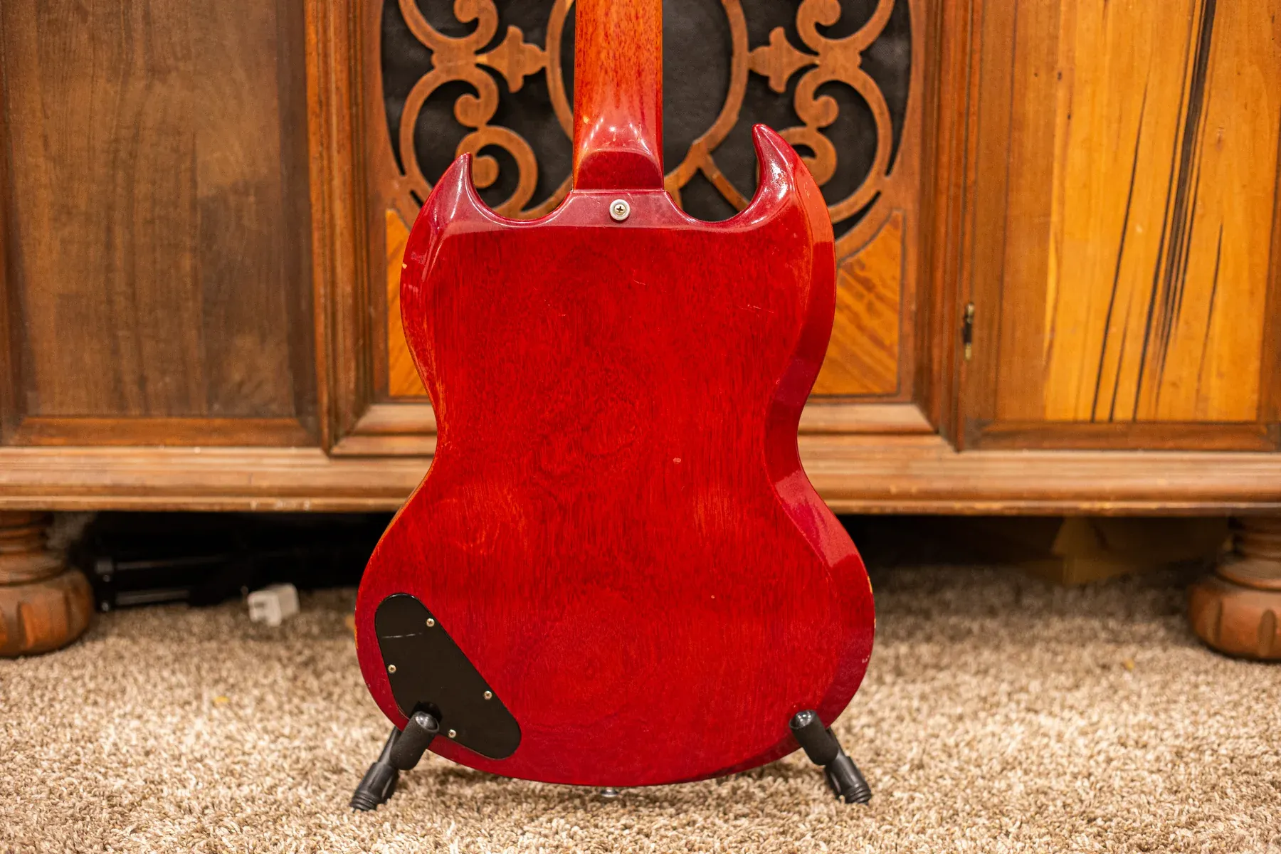 Back of a cherry SG Junior showing the neck joint and black control cavity cover