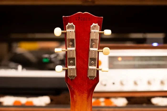 Back of a 1964 Gibson SG Junior headstock showing serial number and strip tuners