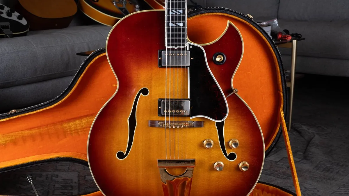 A 1964 Gibson Super 400 CES with a sharp Florentine cutaway, two pickups, and a Super 400 tailpiece, in an orange-lined case.