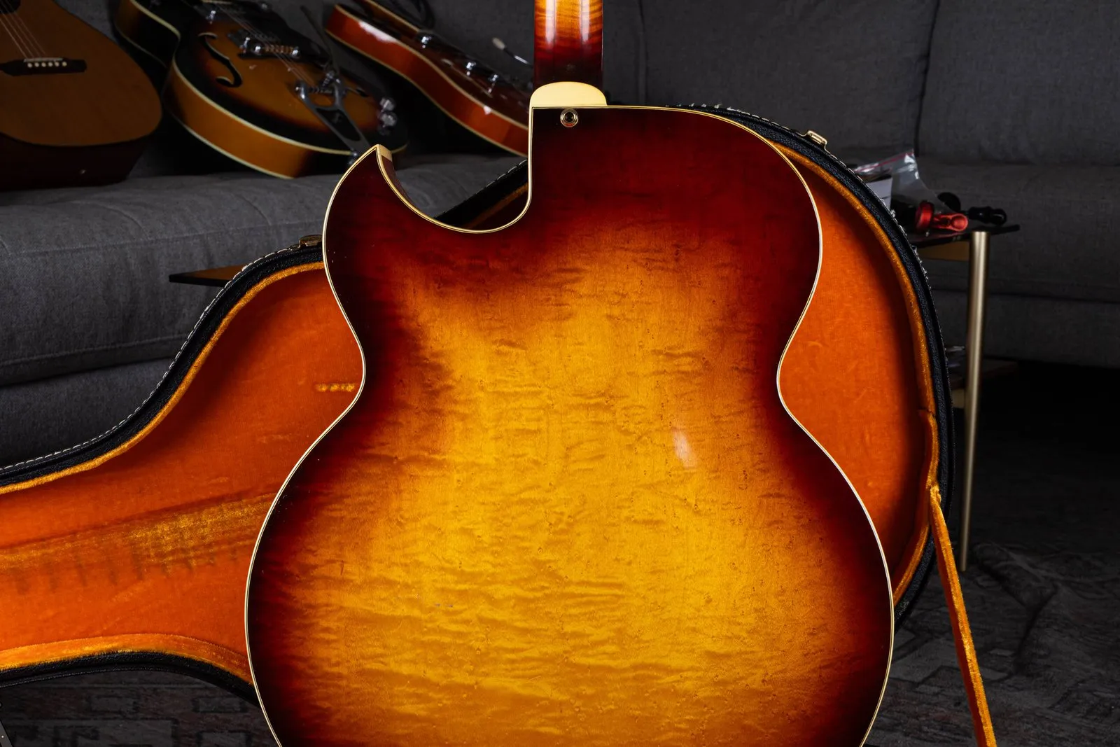 Figured maple back of a 1964 Gibson Super 400 CES, showing the sharp Florentine cutaway and orange case lining.