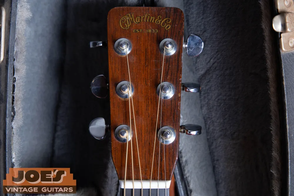 Gold C F Martin and Co script with a dark outline and EST. 1833 lettering on a 1965 Martin D-28 headstock
