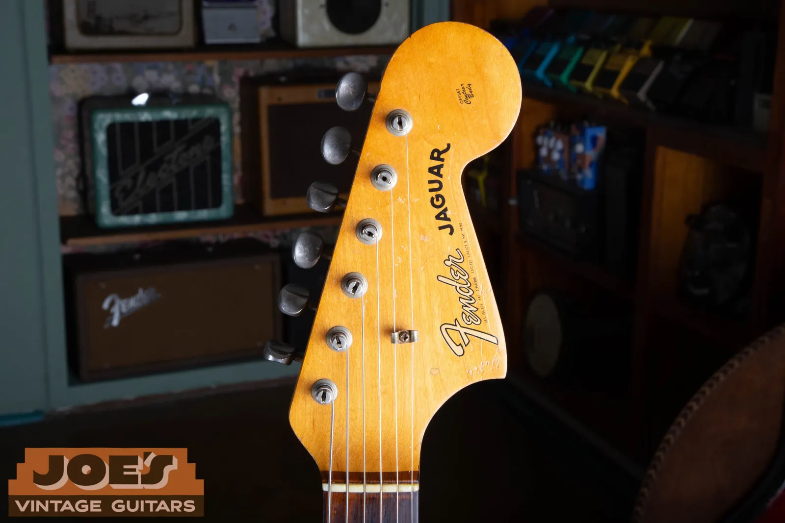 The gold transition headstock logo on a 1965 Fender Jaguar, showing the heavier rounded gold Fender script with the Jaguar model name below it