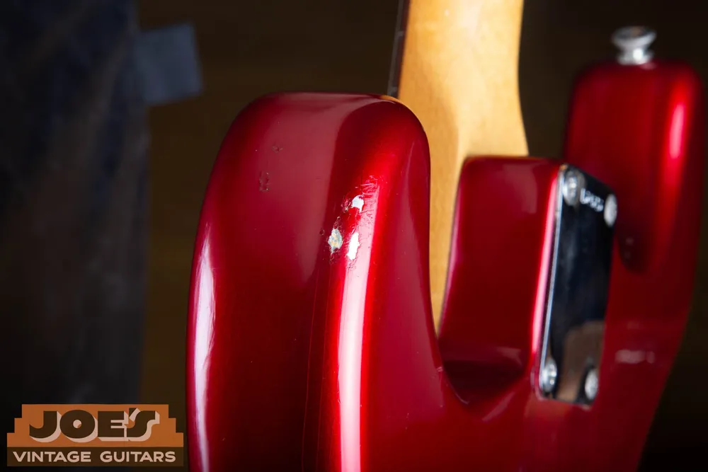 Finish chip on a 1965 Candy Apple Red Fender Stratocaster exposing the metallic silver undercoat
