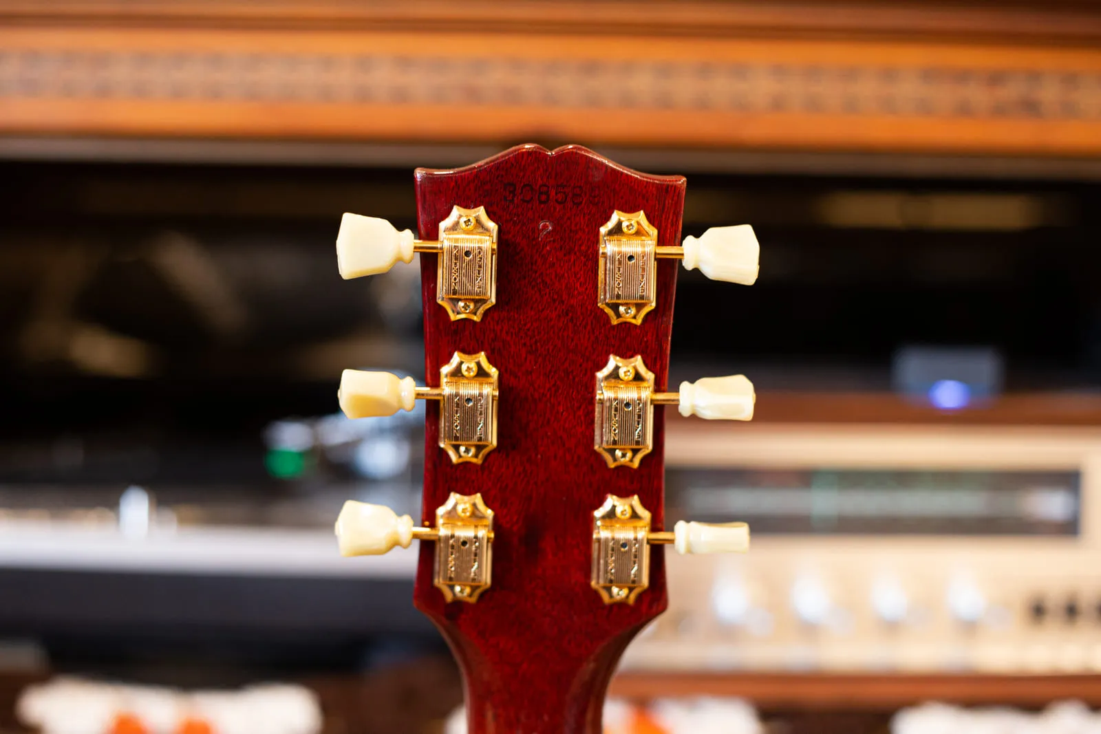 Back of the headstock of a 1965 Gibson Hummingbird showing the impressed serial number 308580 above gold Kluson tuners with cream plastic buttons.