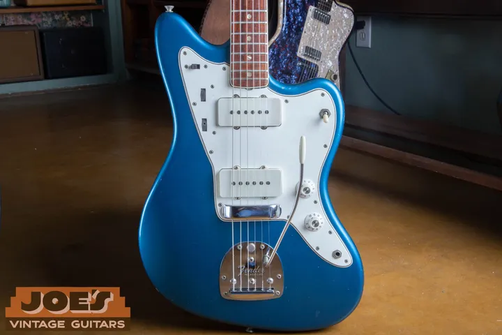 Blue Jazzmaster body with a white pickguard, two white pickup covers and a vibrato arm