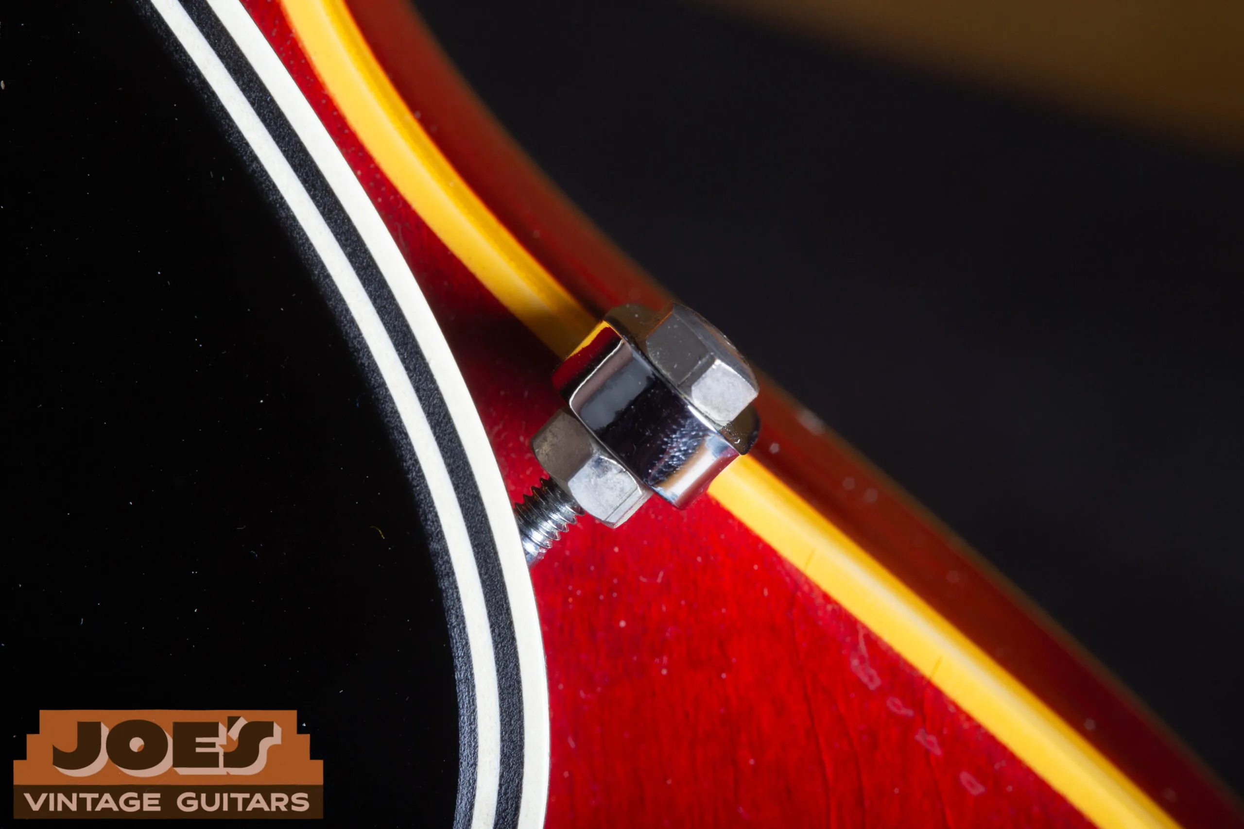 1966 Gibson ES-335 chrome pickguard bracket close-up, metal mounting bracket attaching pickguard to body, showing period-correct chrome aging