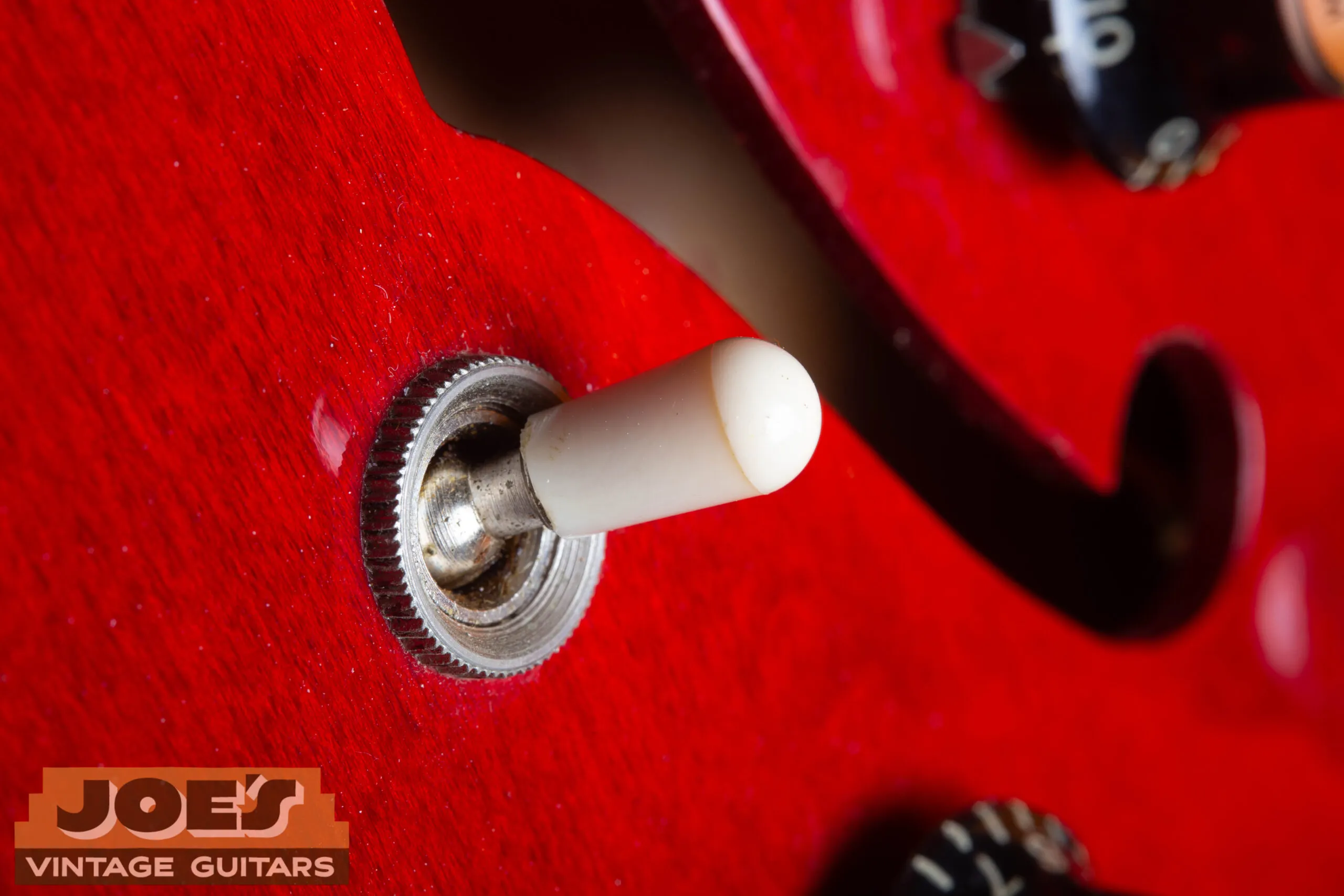 1966 Gibson ES-335 white plastic toggle switch tip close-up, visible mold seam around upper portion confirming period-correct injection-molded tip