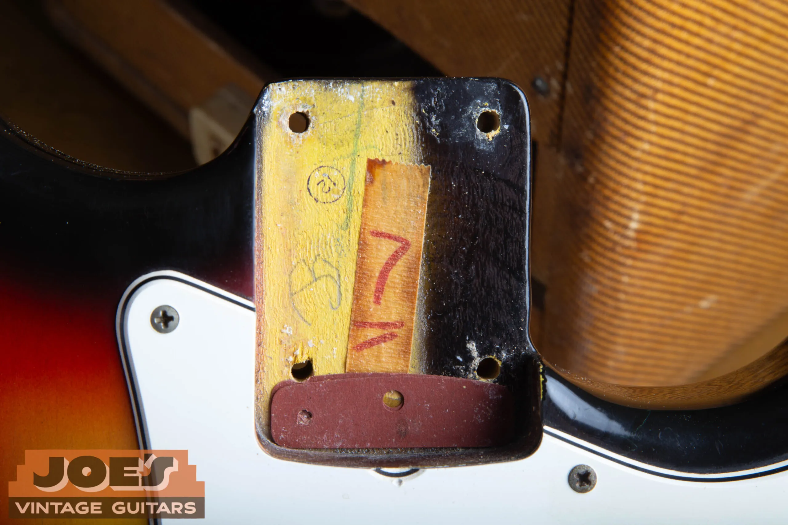 1966 Stratocaster neck pocket showing the paint stick shadow and the original dark red vulcanized fiber shim under the neck heel