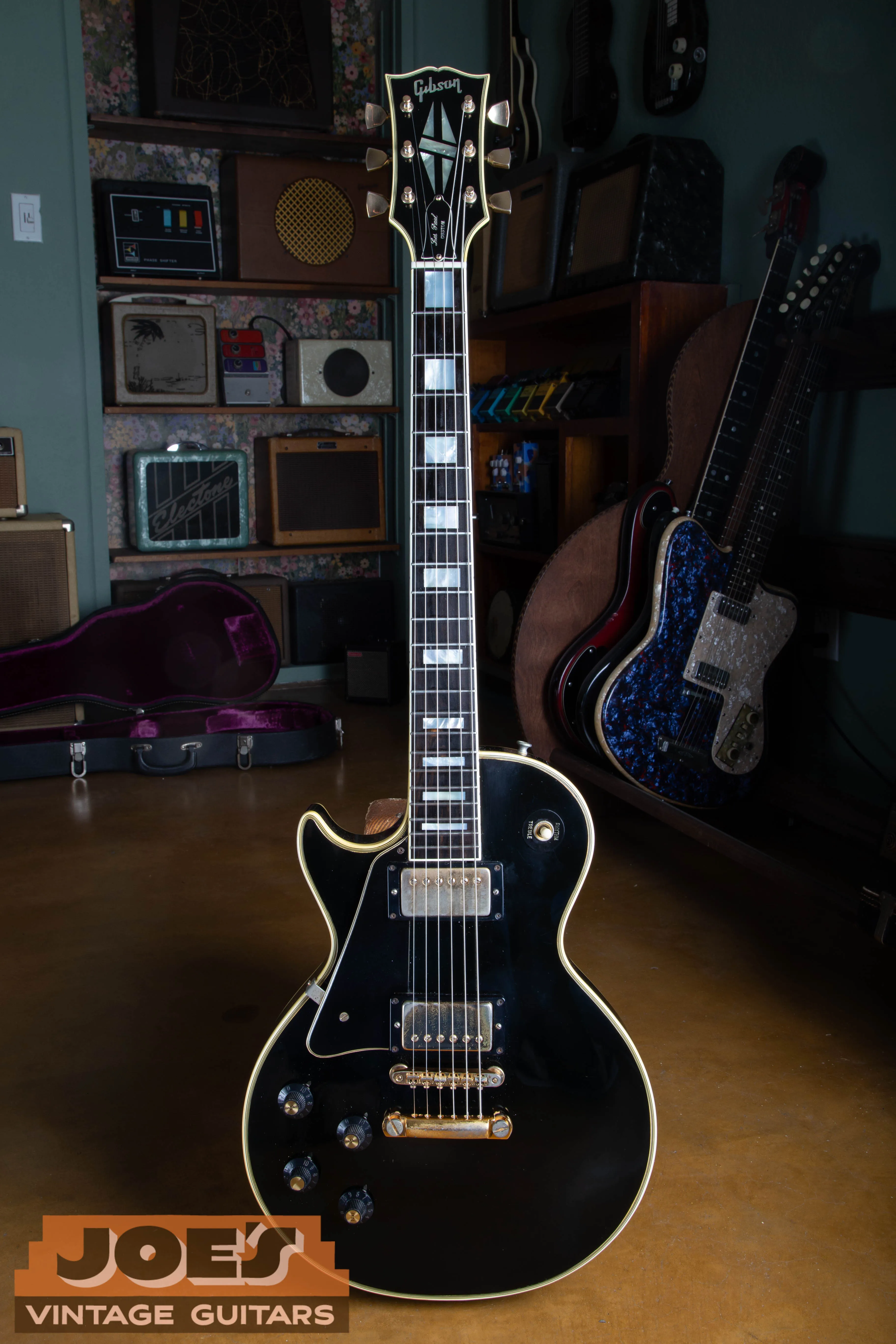 Full front of a black 1969 Les Paul Custom with two covered pickups and a stopbar