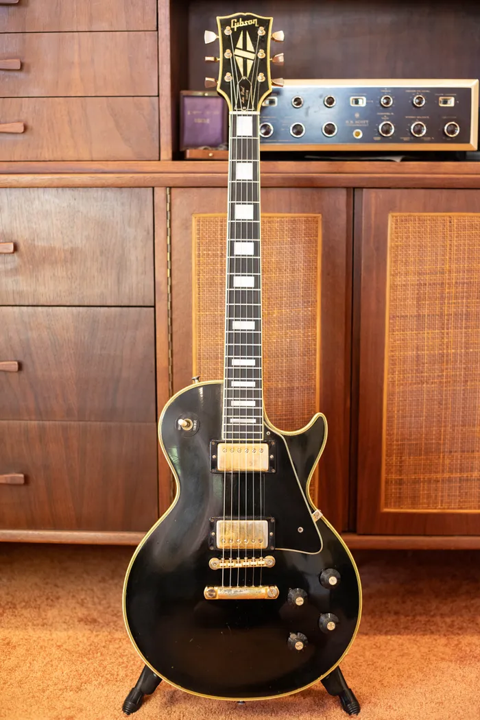 Full-length front view of a black 1970 Gibson Les Paul Custom on a stand